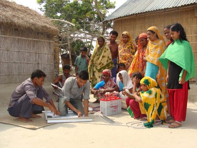 Deutsche-Politik-News.de | Familie in Bangladesch wartet gespannt auf die Installation der Solaranlage. Besonders die Kinder profitieren von dem sauberen Licht, da die gesundheitsschdigenden Abgase der Kerosinlampen entfallen